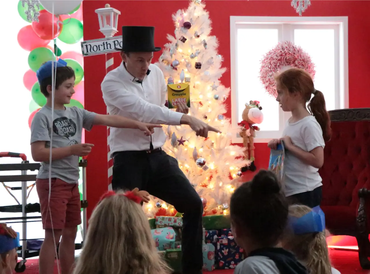 Andy Wonder's magic delights at festive Auckland Christmas party, kids join the fun.