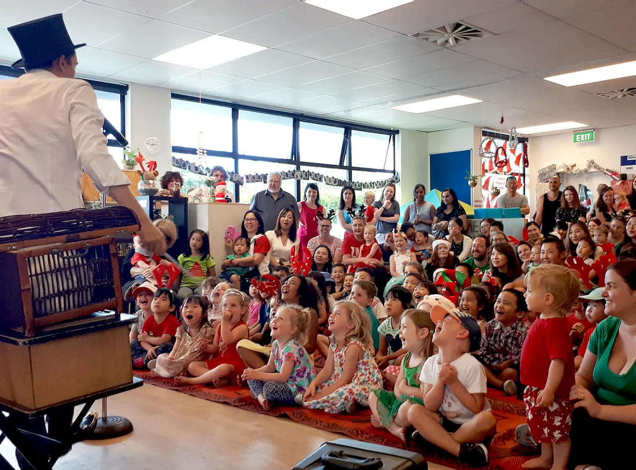 Magician Andy Wonder enchants packed preschool Christmas party with captivating magic.