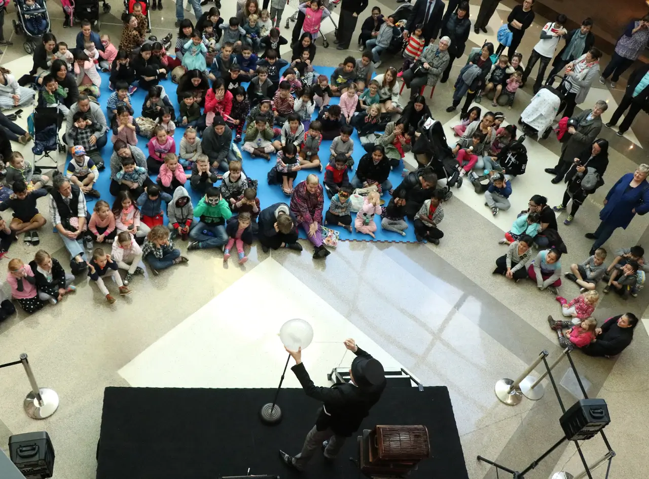 Overhead view: Andy Wonder mesmerises shopping mall crowd with magical balloon trick.
